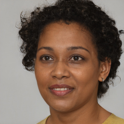 Joyful black adult female with short  brown hair and brown eyes