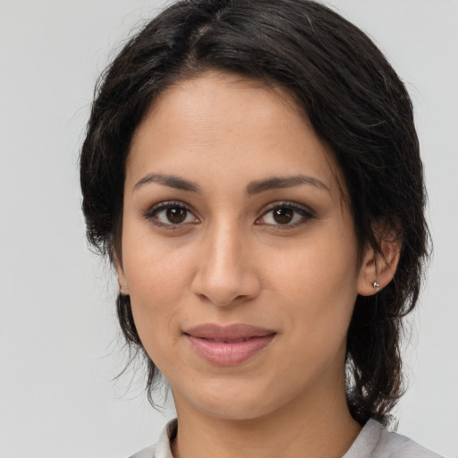 Joyful latino young-adult female with medium  brown hair and brown eyes