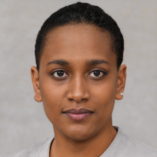 Joyful black young-adult female with short  black hair and brown eyes