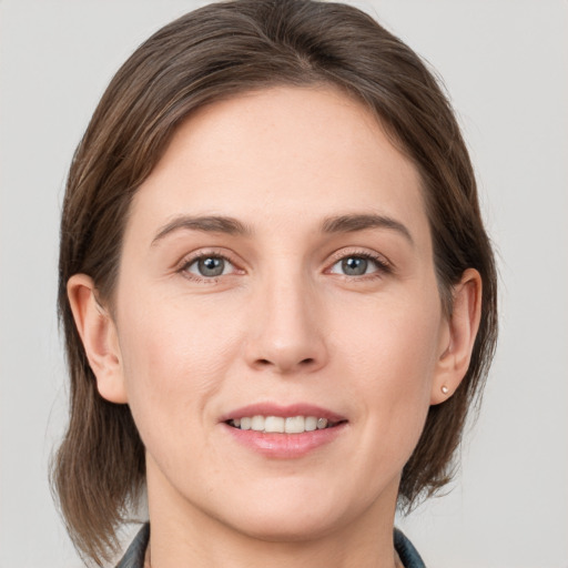 Joyful white young-adult female with medium  brown hair and grey eyes