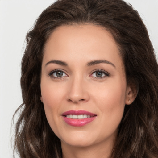 Joyful white young-adult female with long  brown hair and brown eyes