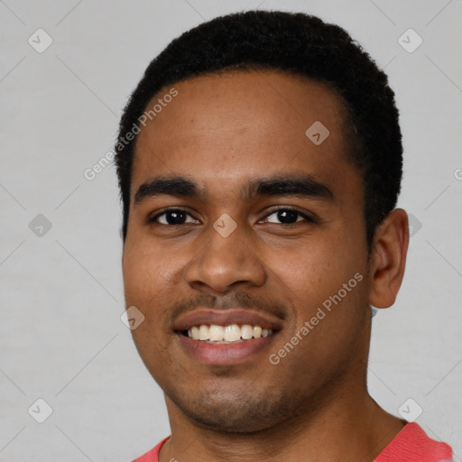 Joyful black young-adult male with short  black hair and brown eyes