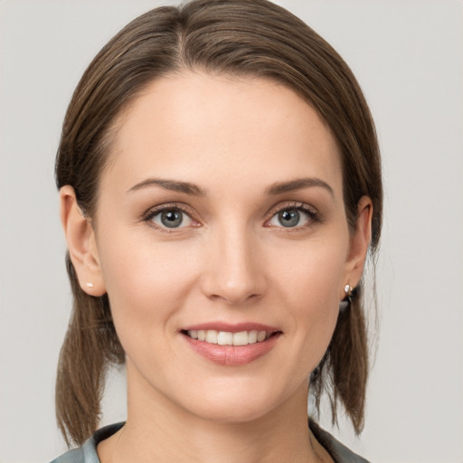 Joyful white young-adult female with medium  brown hair and grey eyes