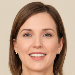 Joyful white young-adult female with medium  brown hair and grey eyes