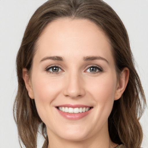 Joyful white young-adult female with long  brown hair and grey eyes