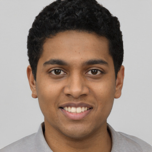 Joyful black young-adult male with short  black hair and brown eyes