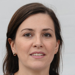 Joyful white adult female with long  brown hair and grey eyes