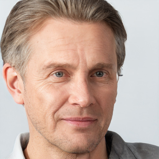 Joyful white adult male with short  brown hair and grey eyes