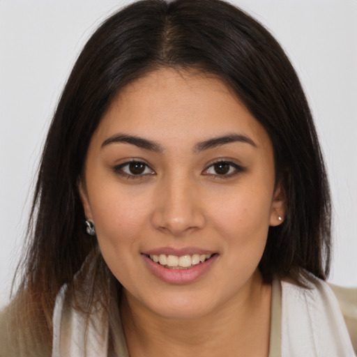 Joyful latino young-adult female with long  brown hair and brown eyes