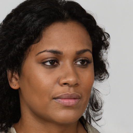 Joyful black young-adult female with long  brown hair and brown eyes