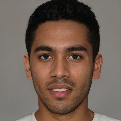 Joyful latino young-adult male with short  black hair and brown eyes