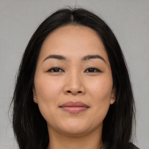 Joyful asian young-adult female with long  brown hair and brown eyes