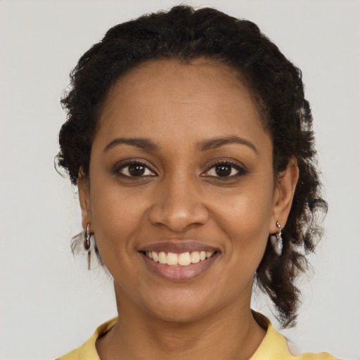 Joyful black young-adult female with short  brown hair and brown eyes
