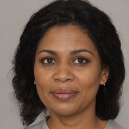 Joyful black adult female with medium  brown hair and brown eyes