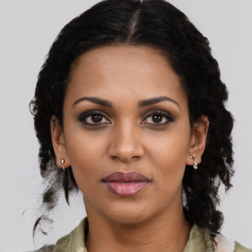 Joyful black young-adult female with long  black hair and brown eyes