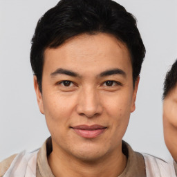 Joyful asian young-adult male with short  black hair and brown eyes