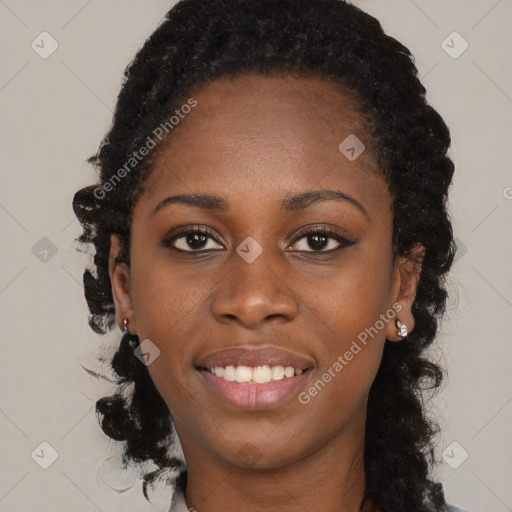 Joyful black young-adult female with long  black hair and brown eyes