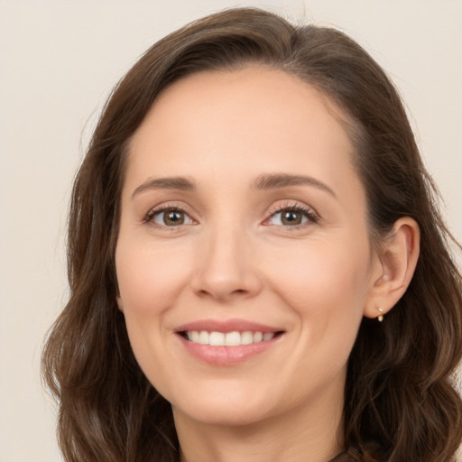 Joyful white young-adult female with long  brown hair and brown eyes