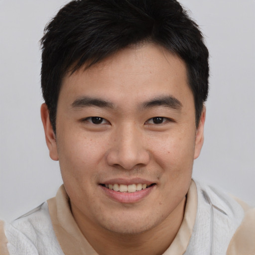 Joyful asian young-adult male with short  brown hair and brown eyes