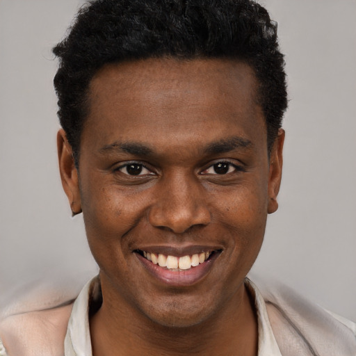 Joyful black young-adult male with short  brown hair and brown eyes