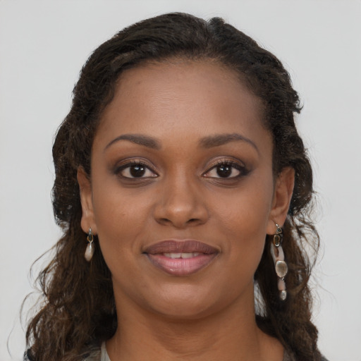 Joyful black young-adult female with long  brown hair and brown eyes