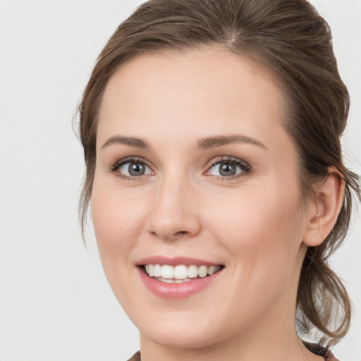 Joyful white young-adult female with medium  brown hair and blue eyes