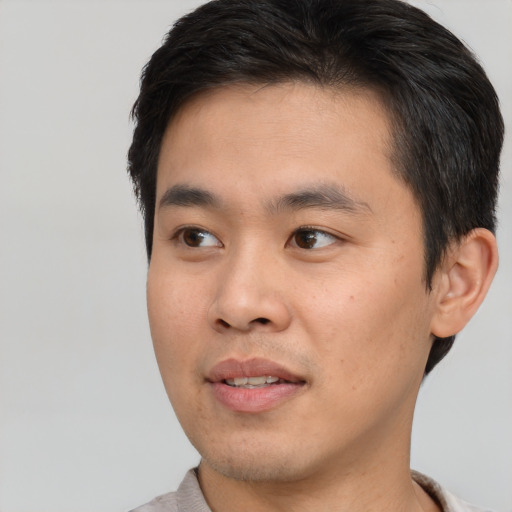 Joyful asian young-adult male with short  brown hair and brown eyes