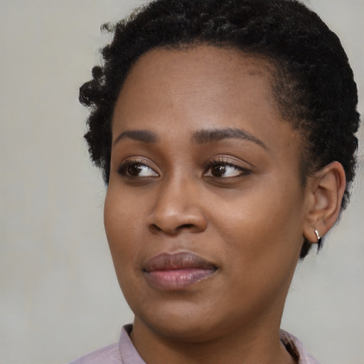 Joyful black young-adult female with short  brown hair and brown eyes