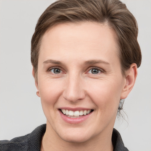 Joyful white young-adult female with short  brown hair and grey eyes