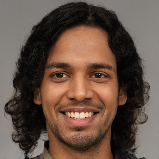 Joyful latino young-adult male with medium  brown hair and brown eyes