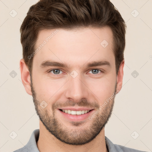 Joyful white young-adult male with short  brown hair and grey eyes