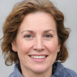 Joyful white adult female with medium  brown hair and blue eyes