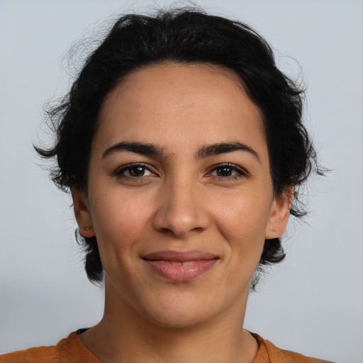 Joyful latino young-adult female with medium  brown hair and brown eyes