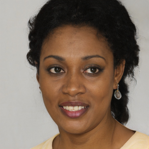 Joyful black young-adult female with short  black hair and brown eyes