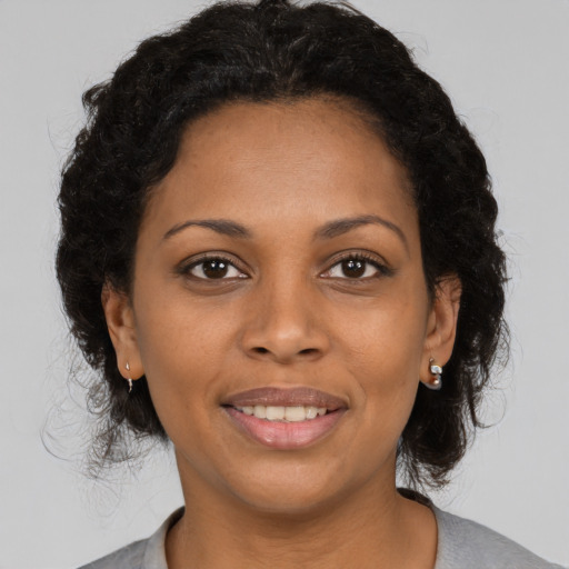 Joyful black young-adult female with medium  brown hair and brown eyes