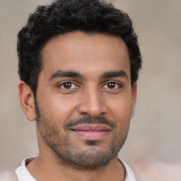 Joyful latino young-adult male with short  black hair and brown eyes