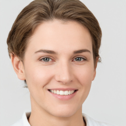 Joyful white young-adult female with short  brown hair and grey eyes