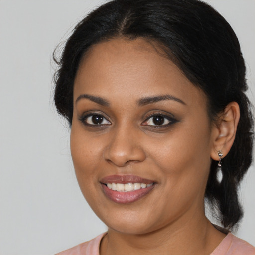 Joyful black young-adult female with long  brown hair and brown eyes