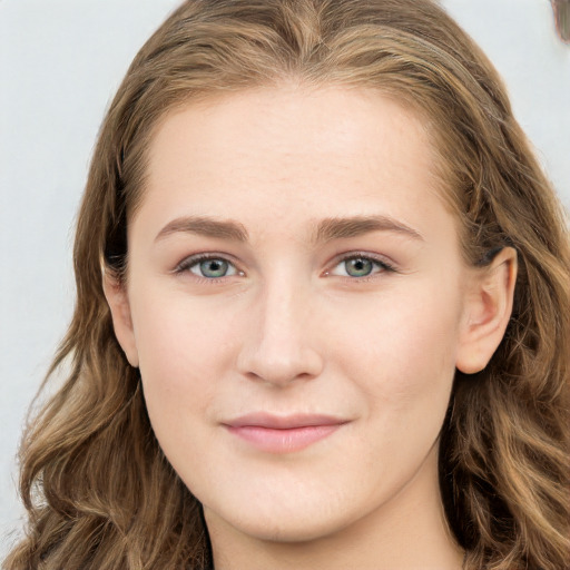 Joyful white young-adult female with long  brown hair and blue eyes