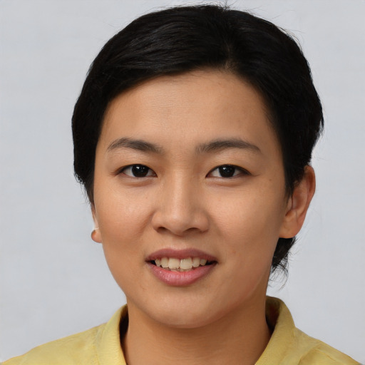 Joyful asian young-adult female with short  brown hair and brown eyes