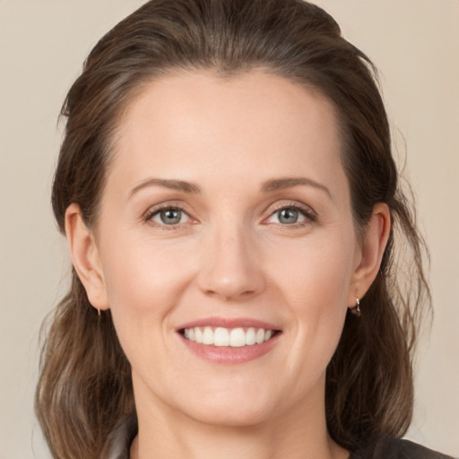 Joyful white young-adult female with medium  brown hair and grey eyes