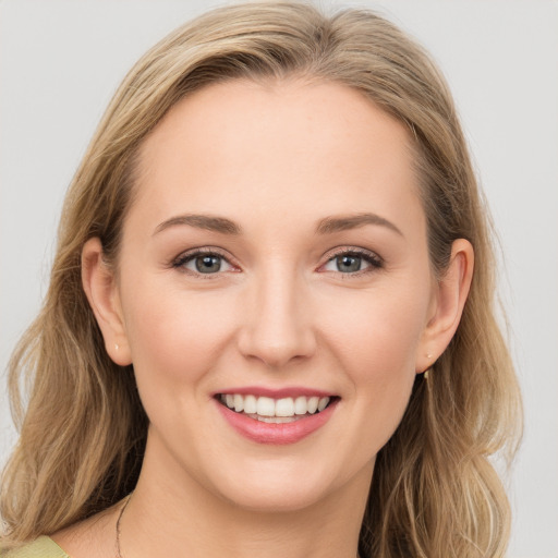 Joyful white young-adult female with long  brown hair and blue eyes