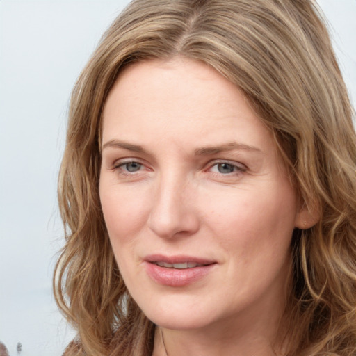 Joyful white young-adult female with long  brown hair and blue eyes