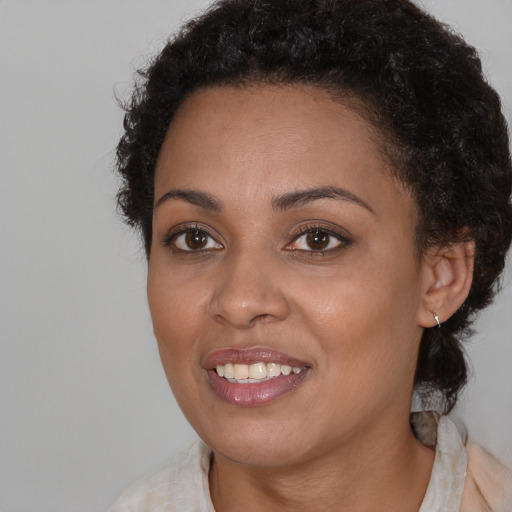 Joyful black young-adult female with medium  brown hair and brown eyes