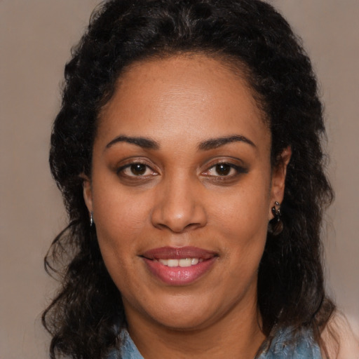 Joyful black young-adult female with long  brown hair and brown eyes