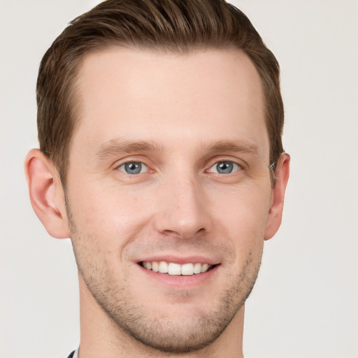 Joyful white young-adult male with short  brown hair and grey eyes