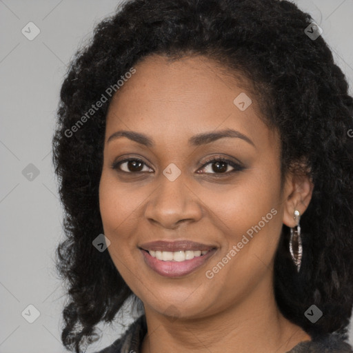 Joyful black young-adult female with long  brown hair and brown eyes