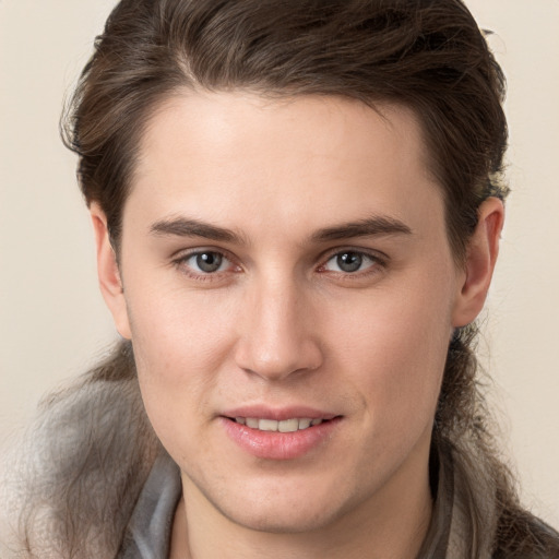 Joyful white young-adult male with long  brown hair and brown eyes