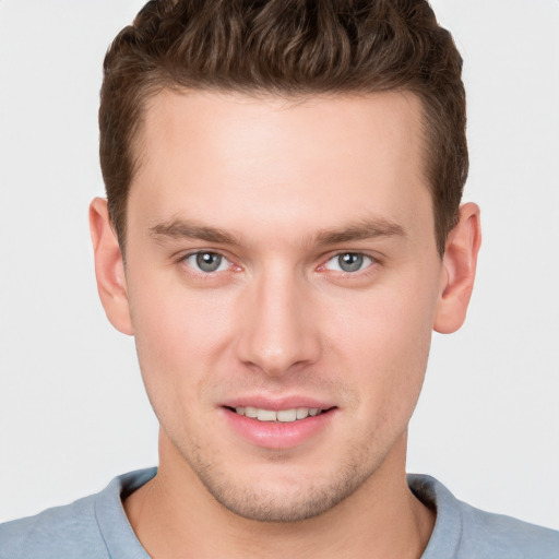 Joyful white young-adult male with short  brown hair and grey eyes