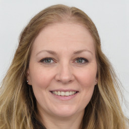 Joyful white adult female with long  brown hair and grey eyes